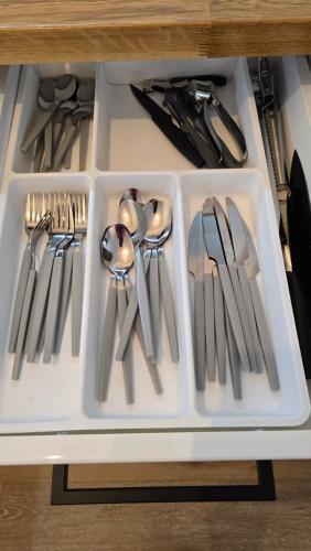 a drawer filled with silver utensils on a table at Apartamenty Rynek 3 Czerwony in Osie
