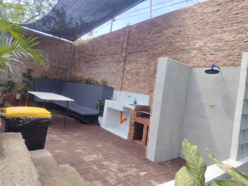 a patio with a table and a brick wall at Casa Del Chen - Budget Friendly Stay - 20-30 Pax in Aringay