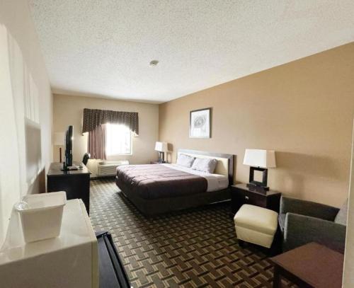 a hotel room with a bed and a couch at FairBridge Inn & Suites Batavia-Darien Amusement Park in Batavia