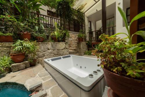 a bath tub in a courtyard with potted plants at Gringo Bill's Boutique Hotel in Machu Picchu