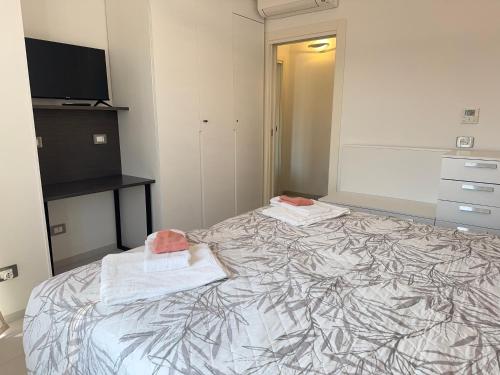 a bedroom with a bed with towels on it at In the Historic Centre, with a View of the Towers in Alba
