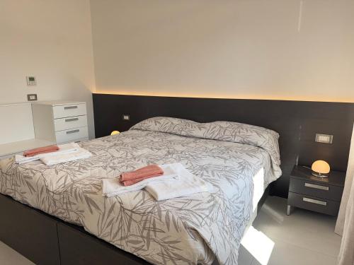 a bedroom with a bed with two towels on it at In the Historic Centre, with a View of the Towers in Alba