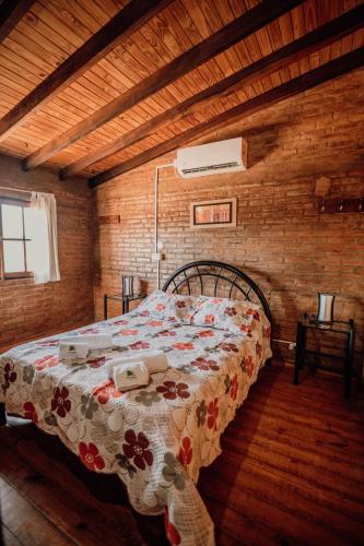 a bedroom with a bed in a wooden room at Cantonavi Cabañas in Mina Clavero