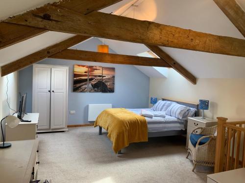 a bedroom with a bed in a room with wooden beams at 1 bed-cottage-Parking-Patio-close to coasts in North Hill