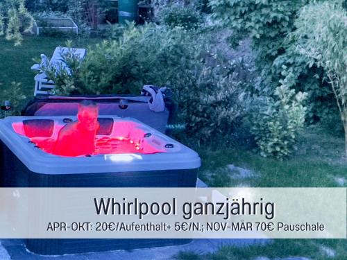 a hot tub with red liquid in it in a yard at OLIVE - Ruhe & Entspannung in 2-Zi-Fewo mit Garten-Whirlpool, Terrasse & Hund willkommen by FerienWohnenAmSee in Überlingen