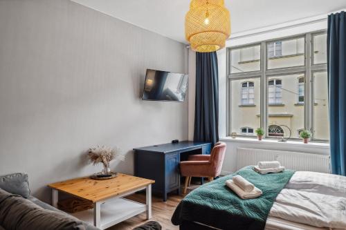 a bedroom with a bed and a table and a tv at NEU Altstadtliebe - gemütliche Apartments in der historischen Altstadt, zentral und komfortabel in Wismar
