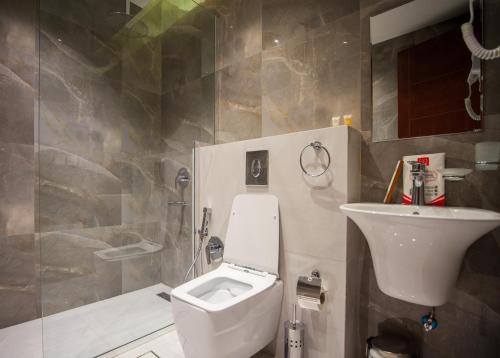 a bathroom with a toilet and a sink at Luxury One-Bedroom Apt AlRimal-3 in Riyadh