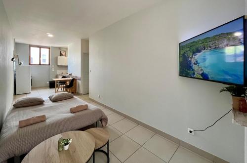 two beds in a room with a tv on the wall at Bel appartement à 15 min de Lyon in Saint-Fons