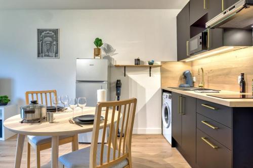 une cuisine avec une table et des chaises dans une cuisine dans l'établissement La Suite quartier de la gare, à Yvetot