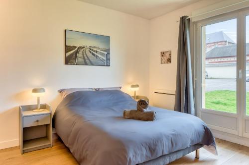une chambre avec un grand lit et une fenêtre dans l'établissement La Suite quartier de la gare, à Yvetot
