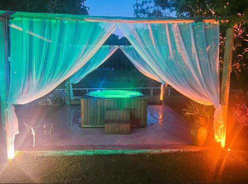 a patio with a tub in a tent with lights at Pousada Jupter in Teresópolis