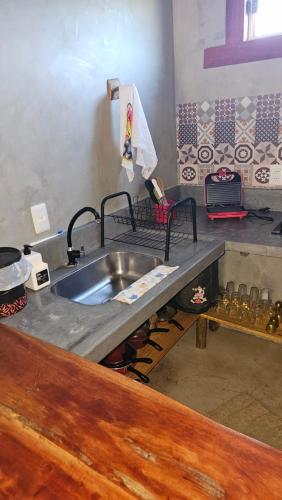 een keuken met een spoelbak en een aanrechtblad bij Chalé do vini in Prado