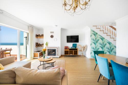 a living room with a couch and a table at Nativo Big Wave Front Row 2BR Nazaré in Nazaré