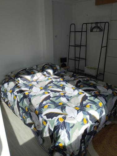 - un lit avec une couette à fleurs dans une chambre dans l'établissement Appartement à la campagne, à Génillé