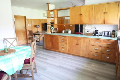 a large kitchen with wooden cabinets and a table at Stay Cardrona Wanaka in Cardrona