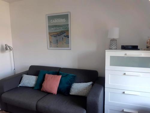 - un salon avec un canapé et des oreillers dans l'établissement Studio à côté de la thalasso, à Cabourg
