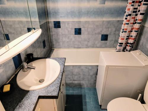 une salle de bain avec un lavabo, des toilettes et une baignoire dans l'établissement Coquet appartement avec piscine à 200m de la plage, à Bandol