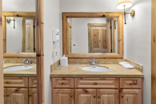 a bathroom with two sinks and two mirrors at Telluride Mountain Lodge Skiin Out amazing location in Telluride
