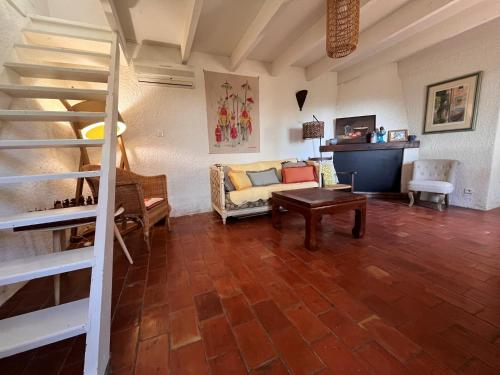 un salon avec un canapé et un escalier dans l'établissement Bastidon provençal Aix-en-Provence plein cœur de la forêt avec vue unique, au Tholonet