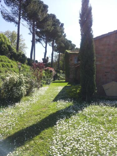 a garden with trees and flowers in the grass at Alloggio Al San Girolamo in Longiano
