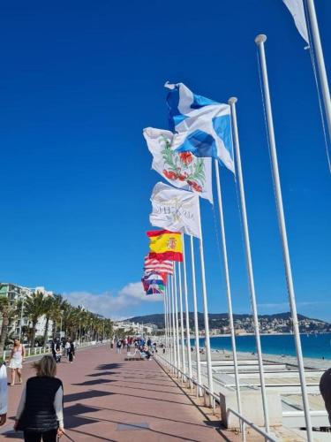 a row of flags on a boardwalk on a beach at Royal Studio Massena in Nice