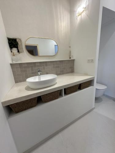une salle de bain avec un lavabo et un miroir dans l'établissement Chai rénové plein centre à 5minutes à pied de la plage, à Sainte-Marie de Ré