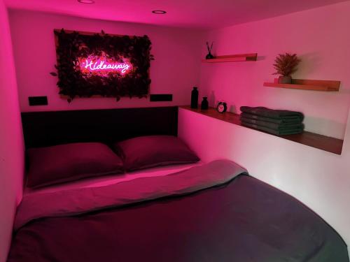 a bedroom with a bed with a neon sign on it at Wellness Chata Hideaway se saunou a vířivkou in Třebechovice pod Orebem