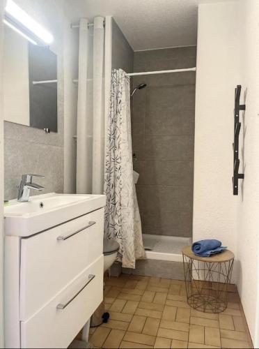 une salle de bain blanche avec un lavabo et une douche dans l'établissement Studio Namasté - à 3 min de la mer, à La Grande Motte