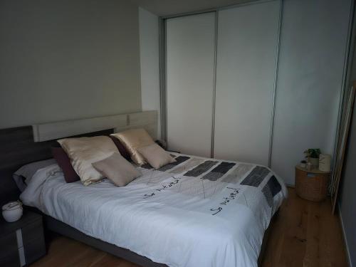 une chambre avec un lit avec des draps blancs et des oreillers dans l'établissement Echoppe Bordelaise, à Bordeaux