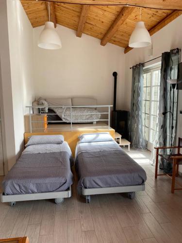 two beds in a room with wooden ceilings at Happy Nest in Sulmona