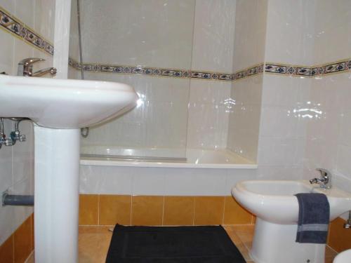 a bathroom with a sink and a toilet and a tub at Zona Las Catedrales Barreiros Playa de Altar in Villadaíde