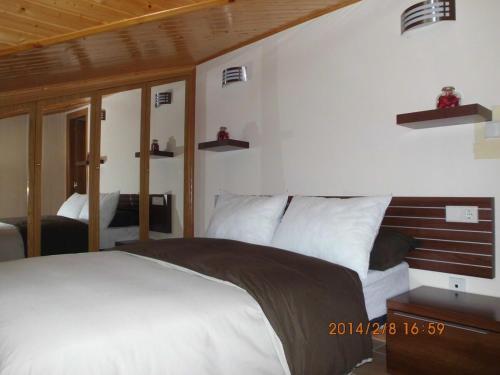 a bedroom with a large white bed and two mirrors at Zona Las Catedrales Barreiros Playa de Altar in Villadaíde