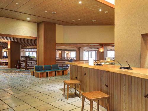 a lobby with a bar with benches and tables at Ookawaso in Aizuwakamatsu