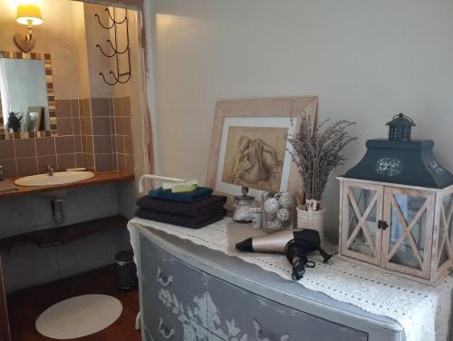 a bathroom with a vanity with a sink and a mirror at Ô fil de L'ô in Clairac