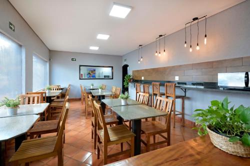 un ristorante con tavoli, sedie e un bancone di HOTEL SENADoR a Ribeirão Preto