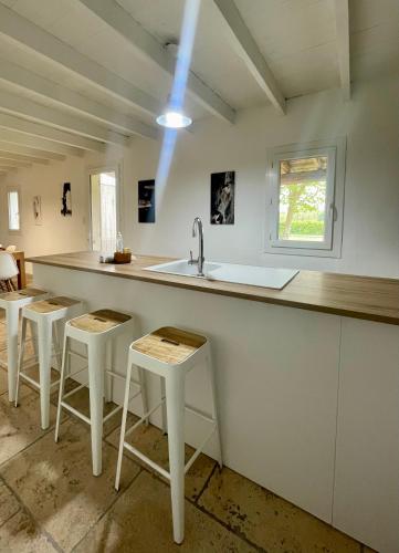 une cuisine avec tabourets et comptoir avec évier dans l'établissement Magnifique gîte 12 couchages, à Arles