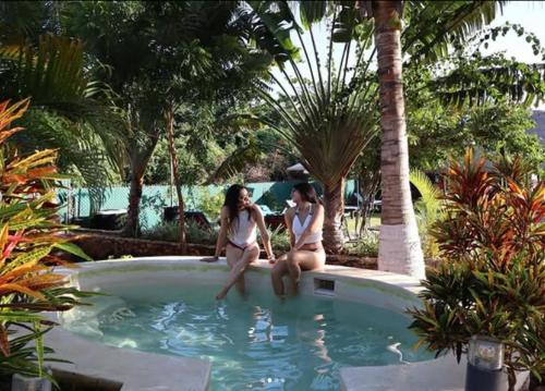 two women are sitting in a swimming pool at Hameki in Homún