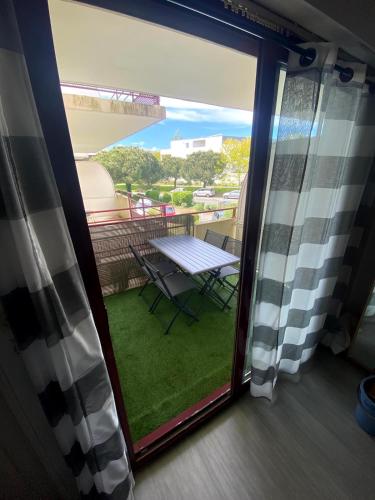 Elle offre une vue sur un balcon doté d'une table et d'une fenêtre. dans l'établissement T2 avec parking sous sol et piscine dans résidence, à La Rochelle