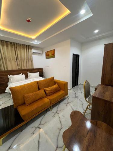 a living room with a couch and a bed at Grand Lynks Homes and Apartments in Gwarinpa