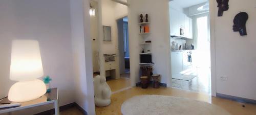 een woonkamer met een keuken en een hal met een lamp bij A casa di Ezio e Paola in La Spezia