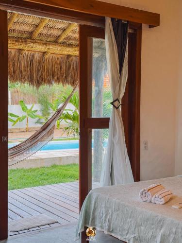 a bedroom with a bed and a window with a hammock at Moitas chalés in Amontada