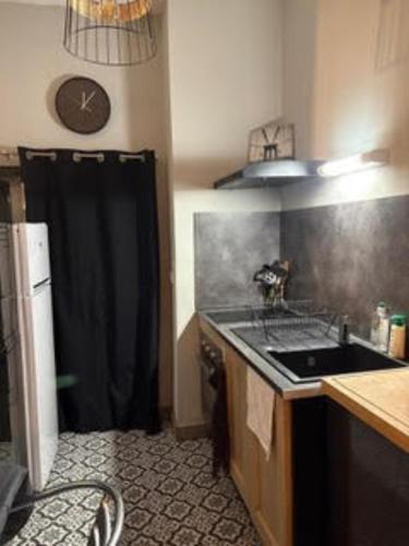 une petite cuisine avec un évier et une cuisinière dans l'établissement T2 Elégant Avignon Coeur Historique Climatisé, à Avignon