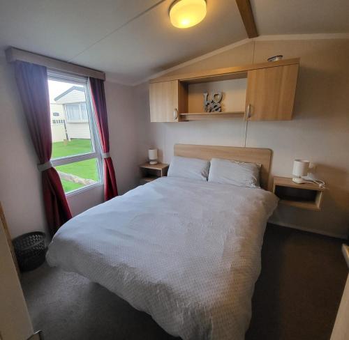 a bedroom with a large bed and a window at Spruce ridge 20 in Filey