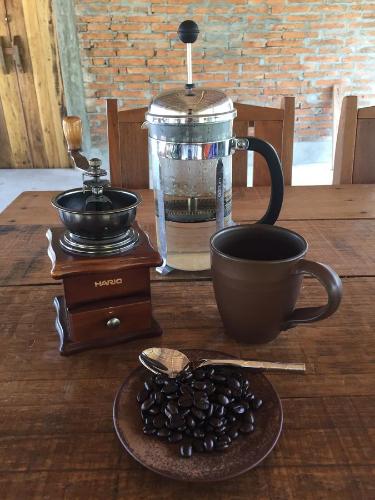 Una mesa con una taza de café y un tazón de granos de café. en Thap Pala Cottage, en Songkhla