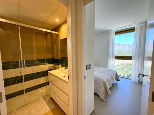 a bathroom with a shower and a sink and a bed at INTEMPO Golden Tower in Benidorm