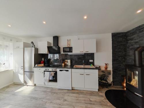 a kitchen with white cabinets and a stove at VipStay - Stilvoll und geräumige Apartments mit Terasse oder Balkon, Küche, kostenloses Parken, WLAN, Smart Tv in Wiesloch