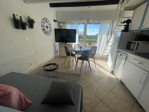 une cuisine et une salle à manger avec une table et des chaises dans l'établissement Le Golfe - Ile des Loisirs - Clim - Piscine - Luna Park, au Cap d'Agde