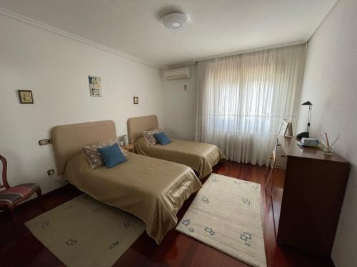 a room with two beds and a table and a window at Apartamento Las Torcas en Mogro in Mogro