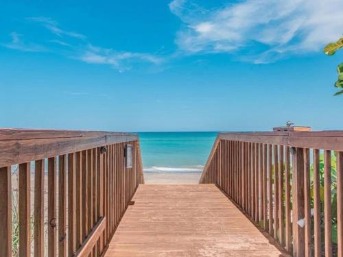 a wooden boardwalk leading to the beach at Hutchinson Island BeachFront Heated Pool Balcony Top Floor Amazing View in Jensen Beach