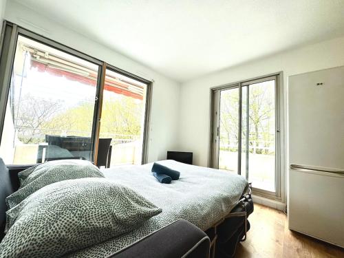 a bedroom with a bed and a large window at Petite Calédonie-Clim-Proche mer in La Grande-Motte